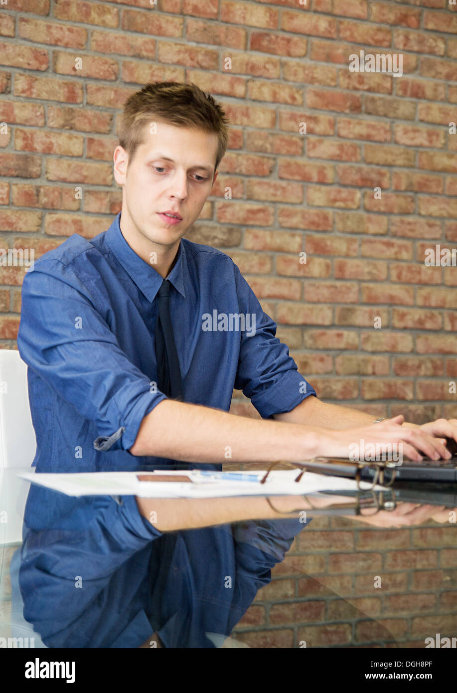 Giovane imprenditore seduta a tavola e lavorare con i grafici Foto Stock