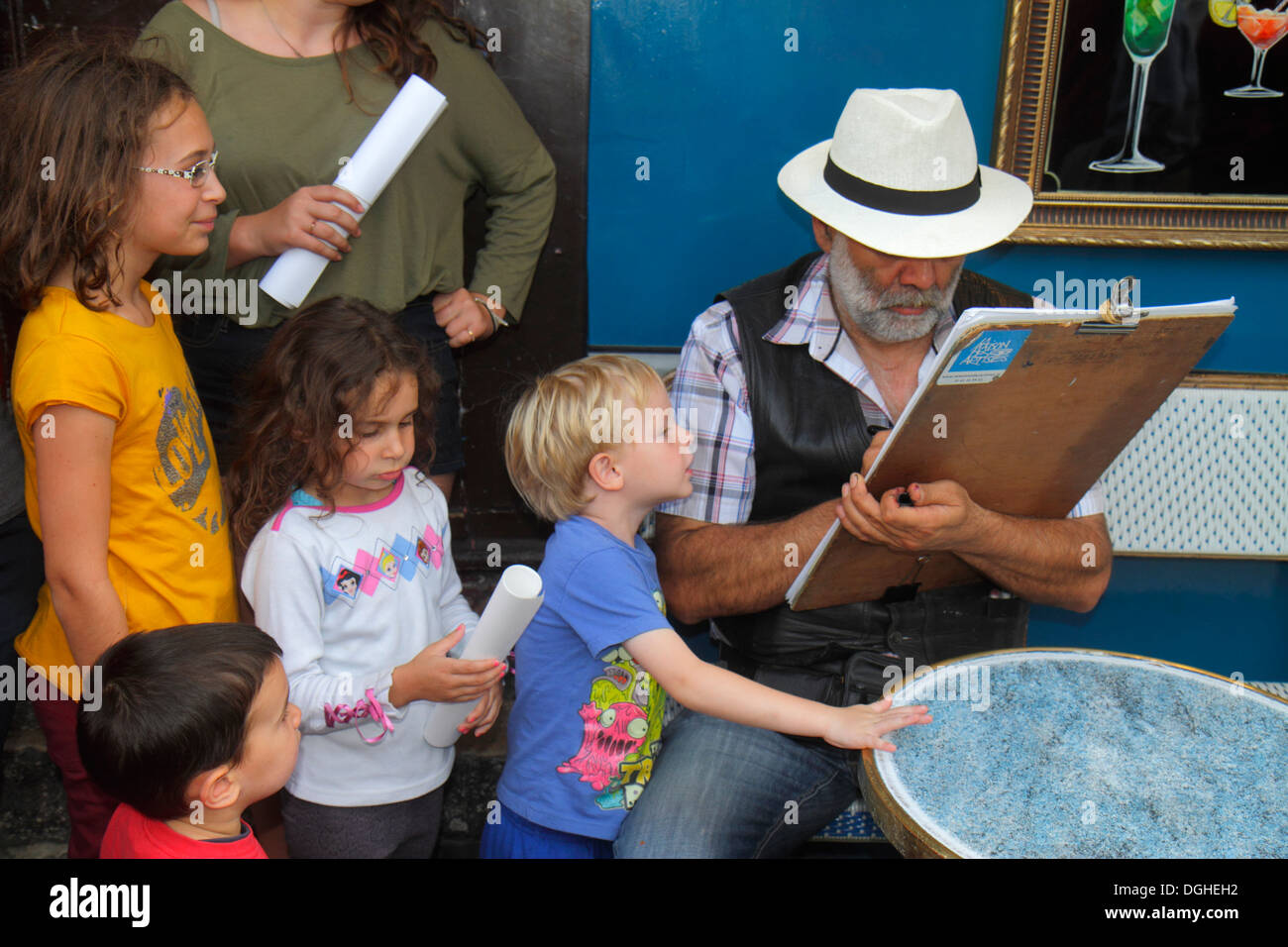 Parigi Francia,18° arrondissement,Montmarre,Place du Tertre,uomo uomo maschio,disegnatore,disegno,ragazzo ragazzi ragazza maschio,ragazze femmina bambini,curioso,Fr Foto Stock