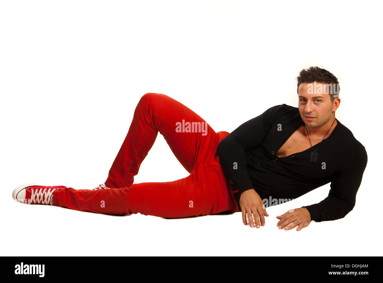 Modello Uomo in rosso i pantaloni e camicia nera sdraiato sul pavimento  Foto stock - Alamy