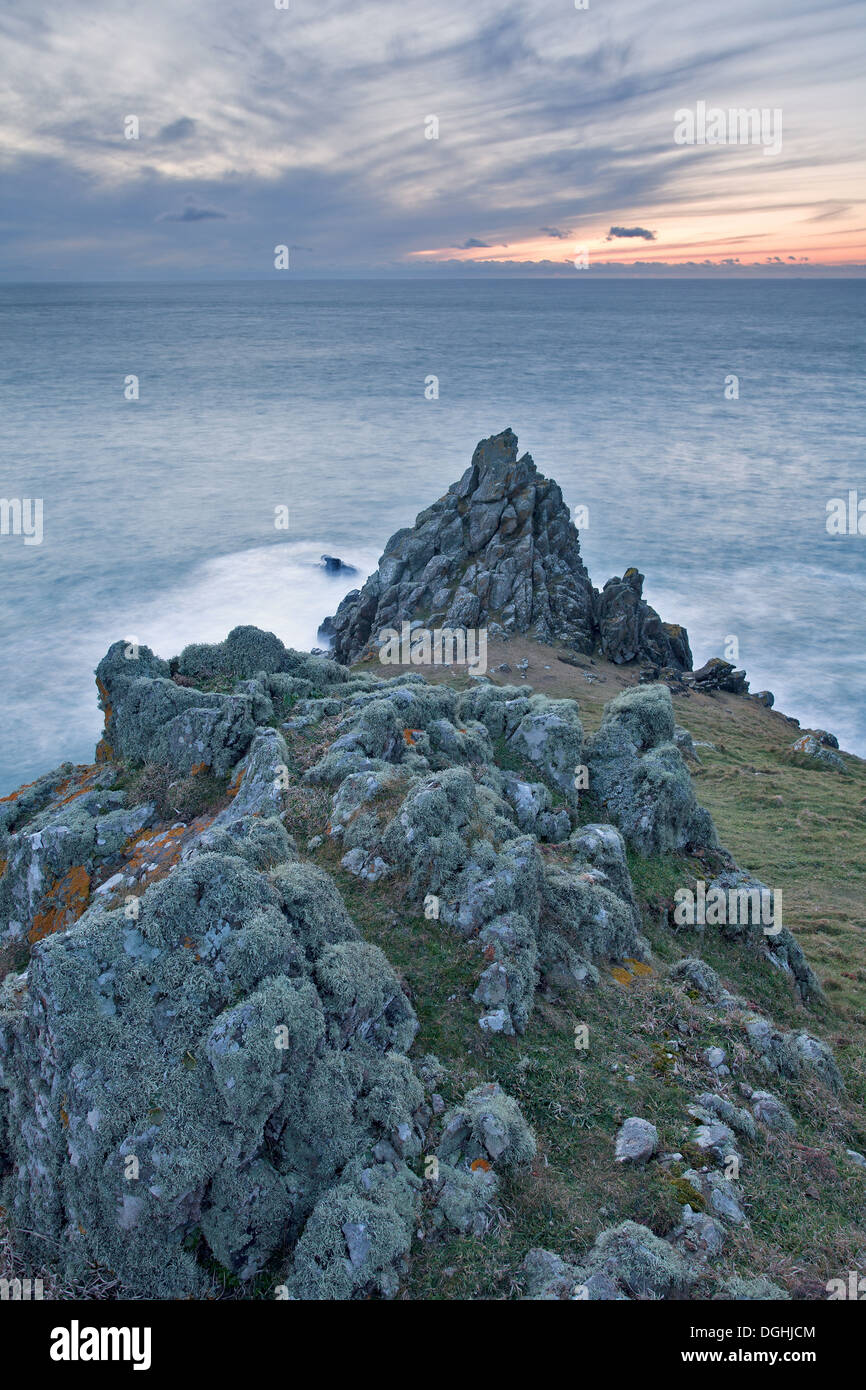 Vista di frastagliate rocce basaltiche sul promontorio costiero al tramonto, Punto di groppe, pentire di testa, Cornwall, Inghilterra, Marzo Foto Stock