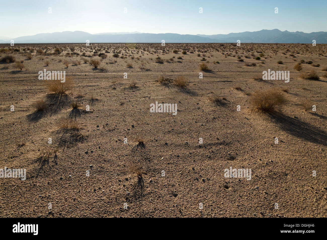 Nel tardo pomeriggio sole sopra l'orizzonte nel deserto vicino alla città della California. Foto Stock