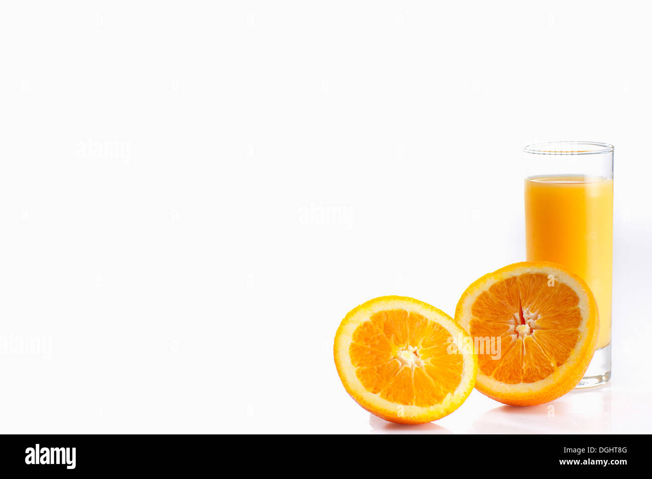 Un bicchiere di succo di arancia accanto a metà arancione Foto Stock