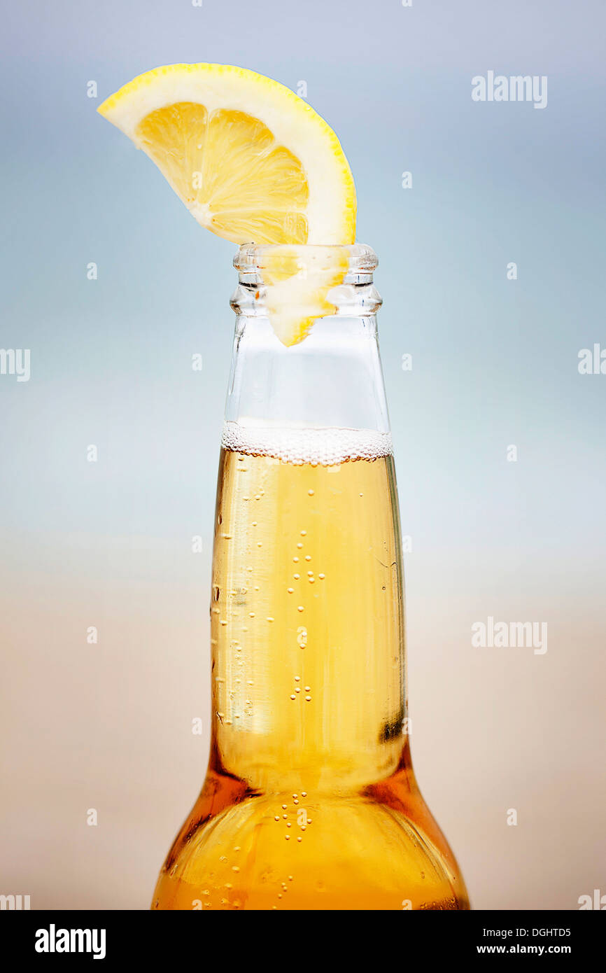 Una birra con una fettina di limone Foto Stock