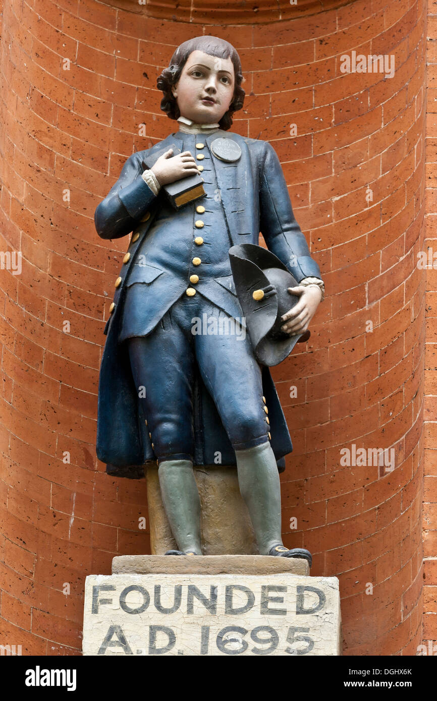 Statua di un ragazzo allievo vestito in uniforme scolastica davanti alla Basilica di San Giovanni di Wapping chiesa scuola per i poveri dell'East End Foto Stock