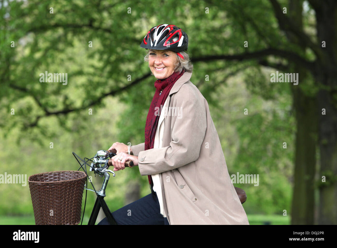 Senior donna bicicletta equitazione nel parco, ritratto Foto Stock