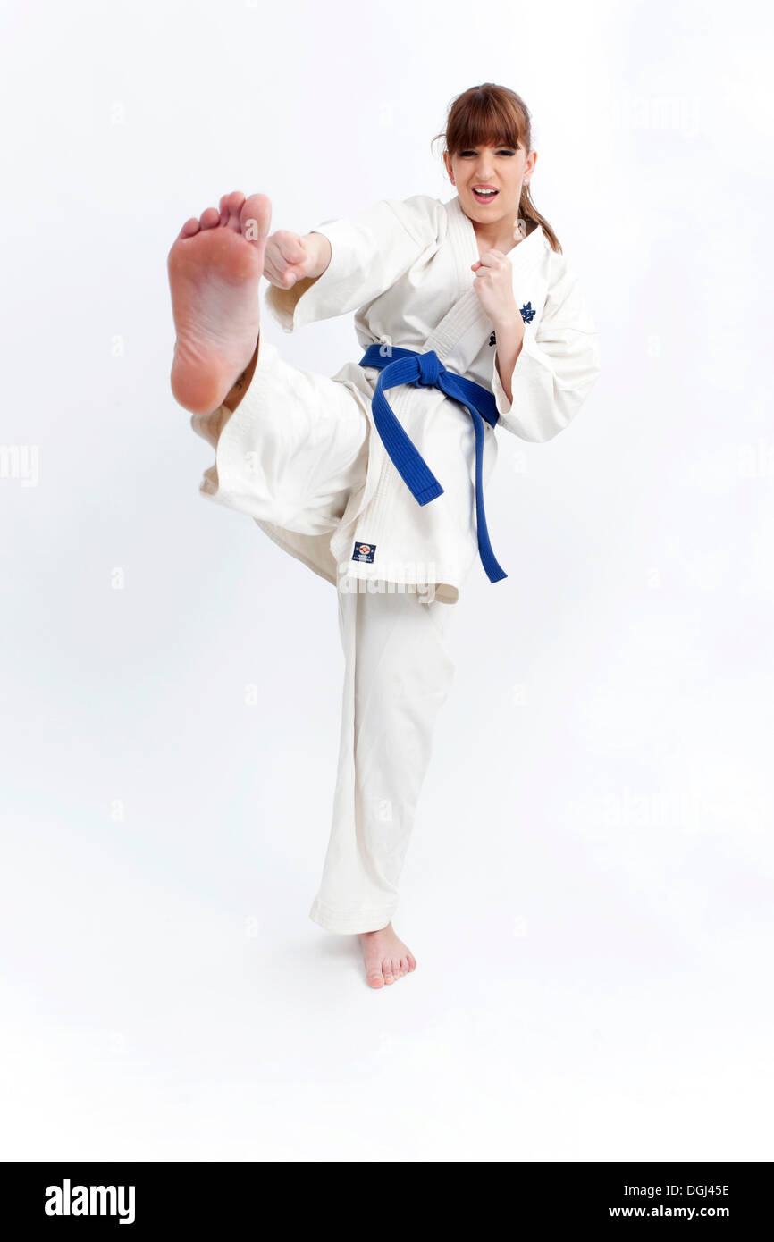 Giovane donna in una tuta di karate la pratica di calci Foto stock - Alamy