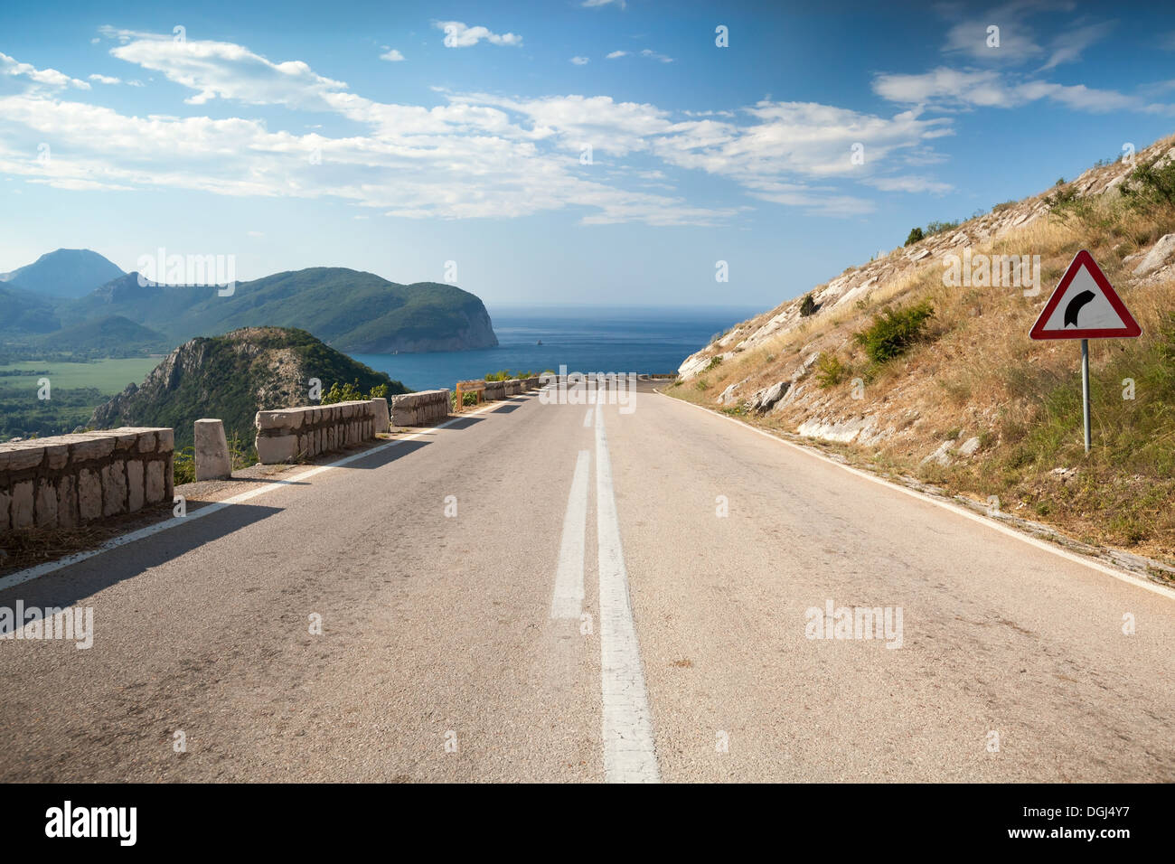 Linea di demarcazione e sterzata a destra cartello sulla montagna costiera in autostrada in Montenegro Foto Stock