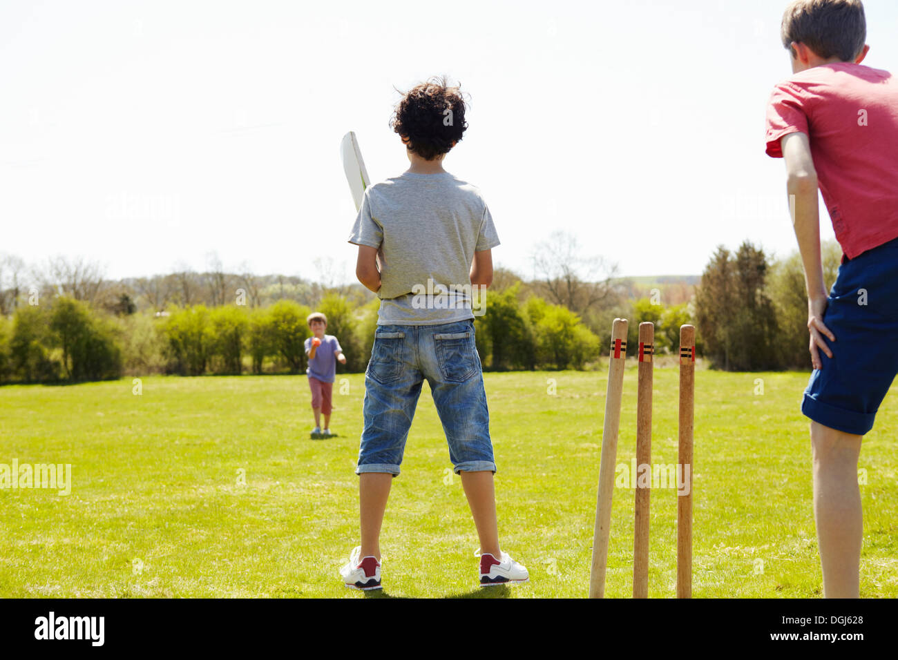 Ragazzi giocare a cricket sul campo Foto Stock