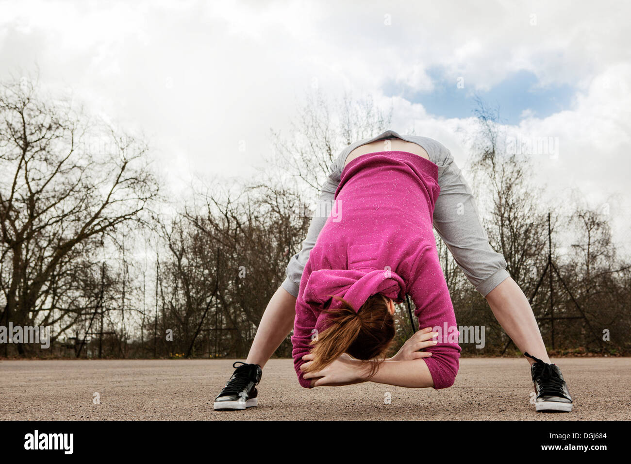 Donna piegatura facendo esercizio di marcia avanti Foto Stock