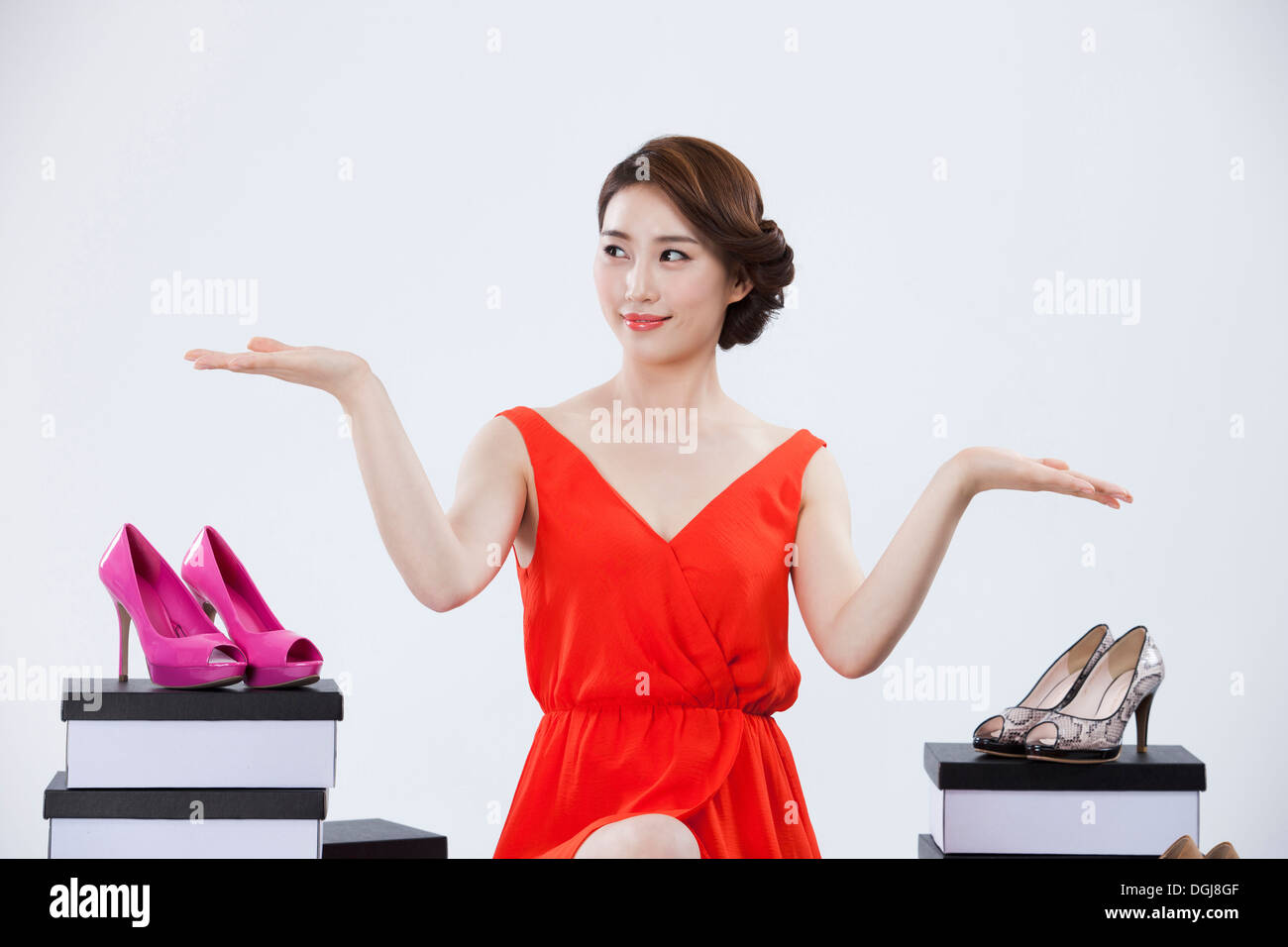 Una donna seduta accanto a una pila di scatole di scarpe Foto Stock