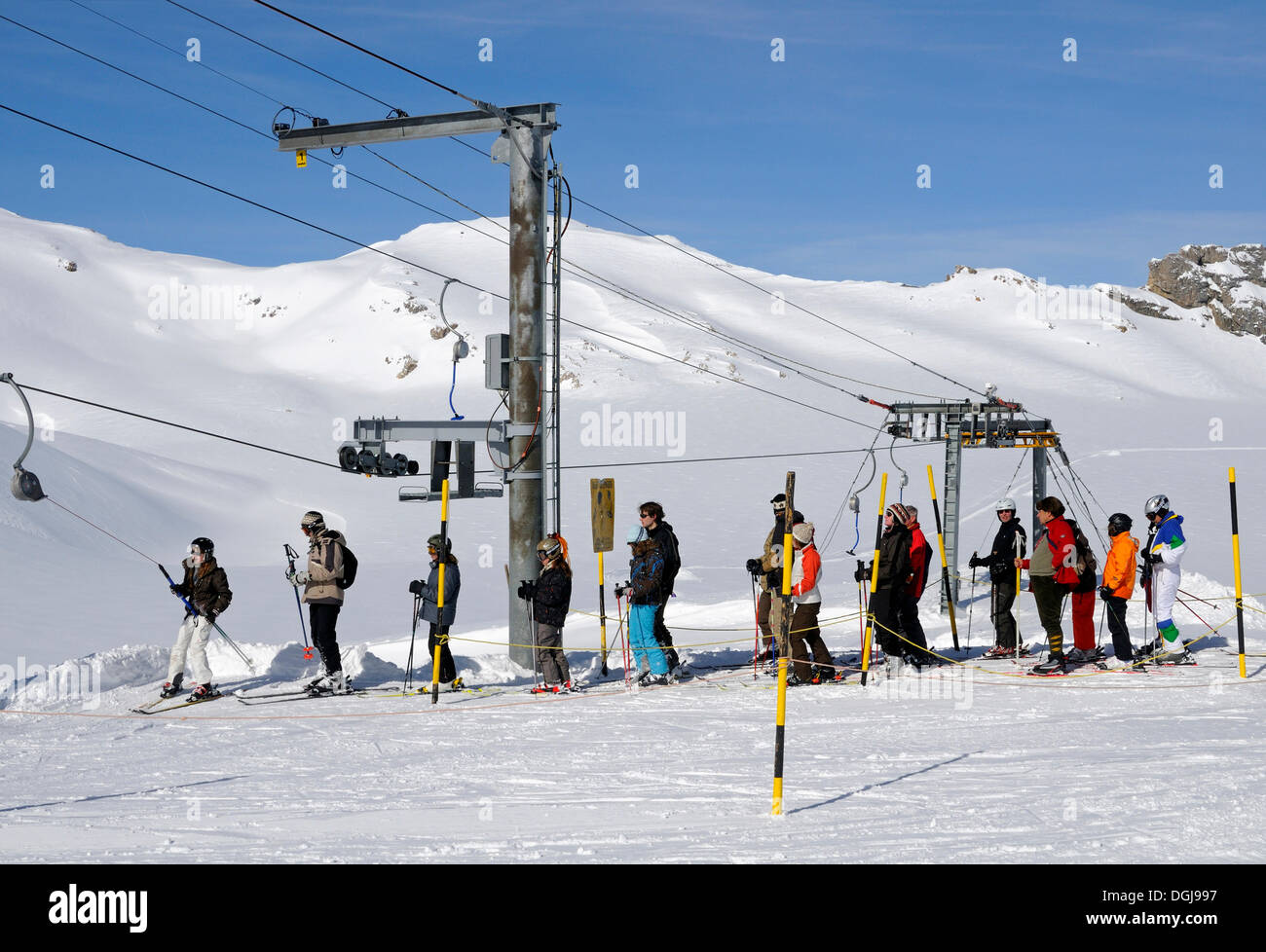 Gli sciatori in attesa presso un impianto di risalita sul ghiacciaio Plaine-Morte, Crans Montana ski resort, Vallese, Svizzera, Europa Foto Stock