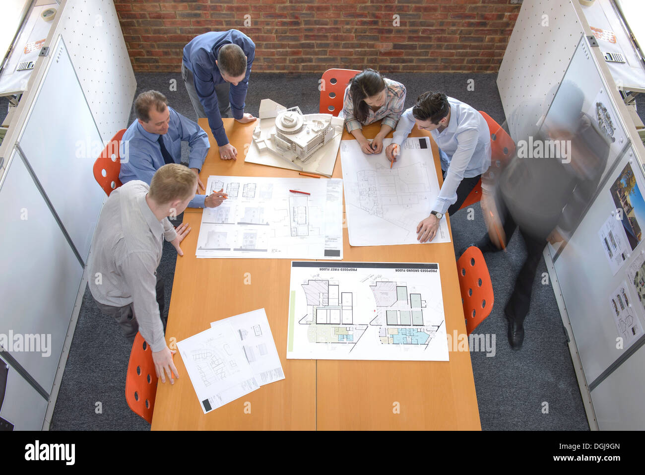 Team di architetti discutendo piani in sala riunioni, movimento sfocato Foto Stock