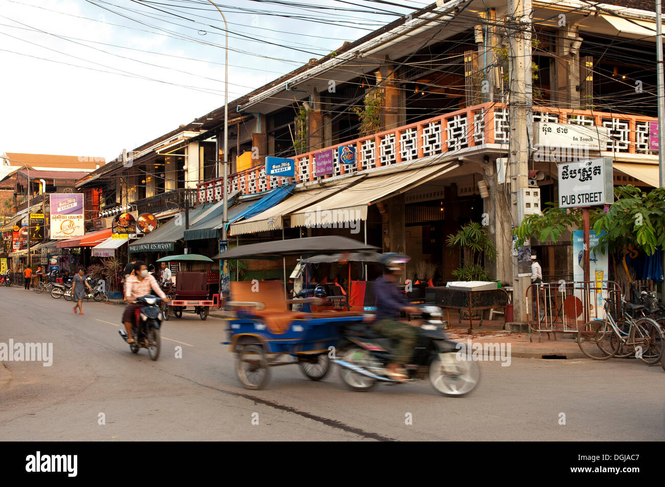 In rickshaw nel traffico di fronte a ristoranti e bar in pub Street, Siem Reap, Siem Reap Provincia, Cambogia Foto Stock