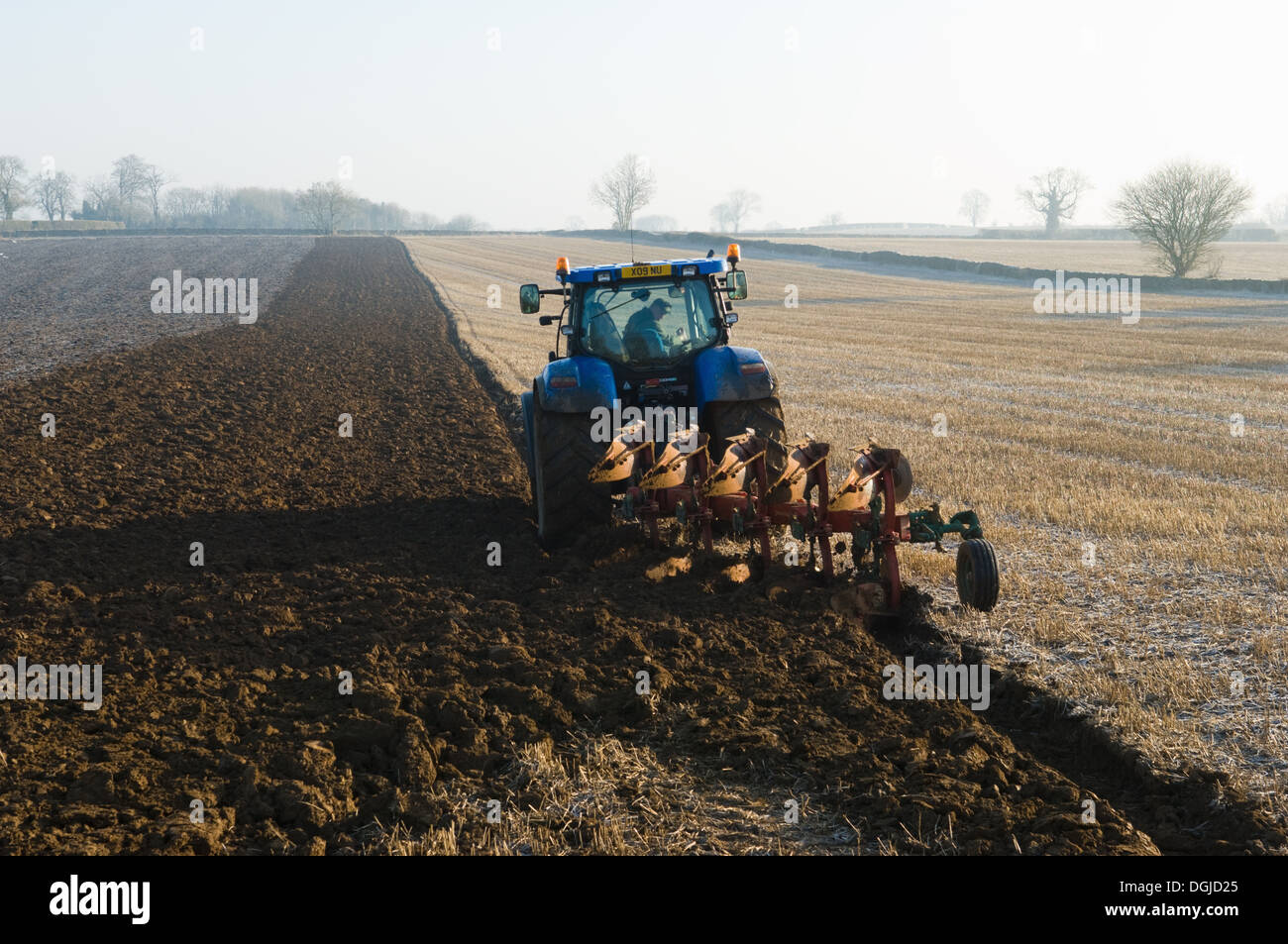 Il trattore arare il terreno del campo Foto Stock