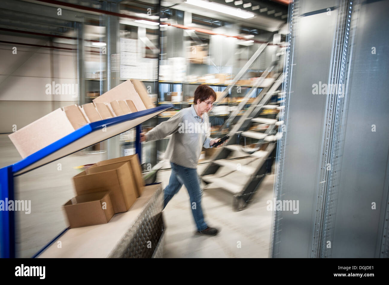 Femmina lavoratore magazzino carrello di movimentazione carrello Foto Stock