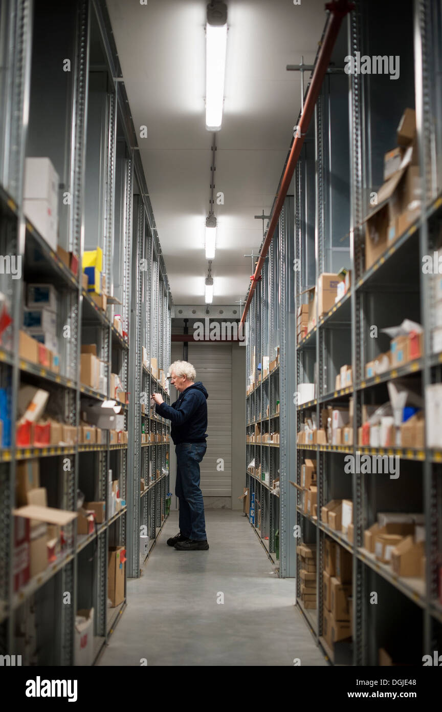 Magazzino maschio lavoratore selezionando la voce da scaffale Foto Stock