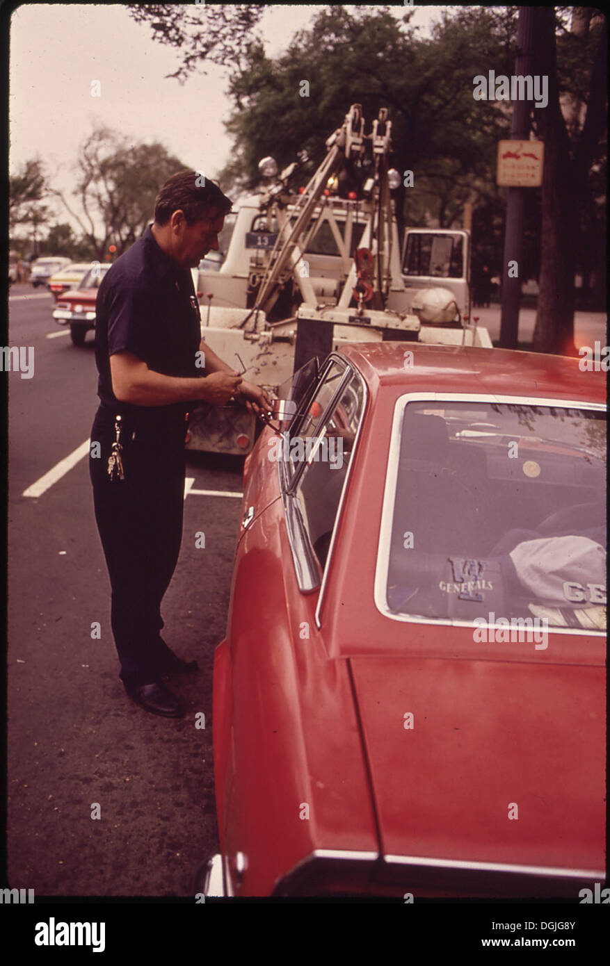 Una fotografia mostra un'auto bloccata che viene aperta e i freni rilasciati, pronta per il traino immediato. Ciò rappresenta l'efficienza delle operazioni di traino del veicolo. Foto Stock