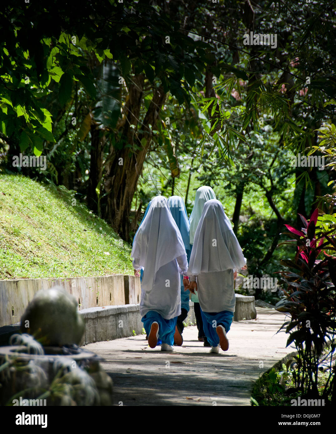Un gruppo di donne studenti musulmani camminare lungo un percorso. Foto Stock