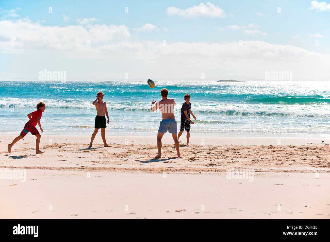 I ragazzi giocare con una palla sul cilindro sulla spiaggia di North Stradbroke Island nel Queensland. Foto Stock