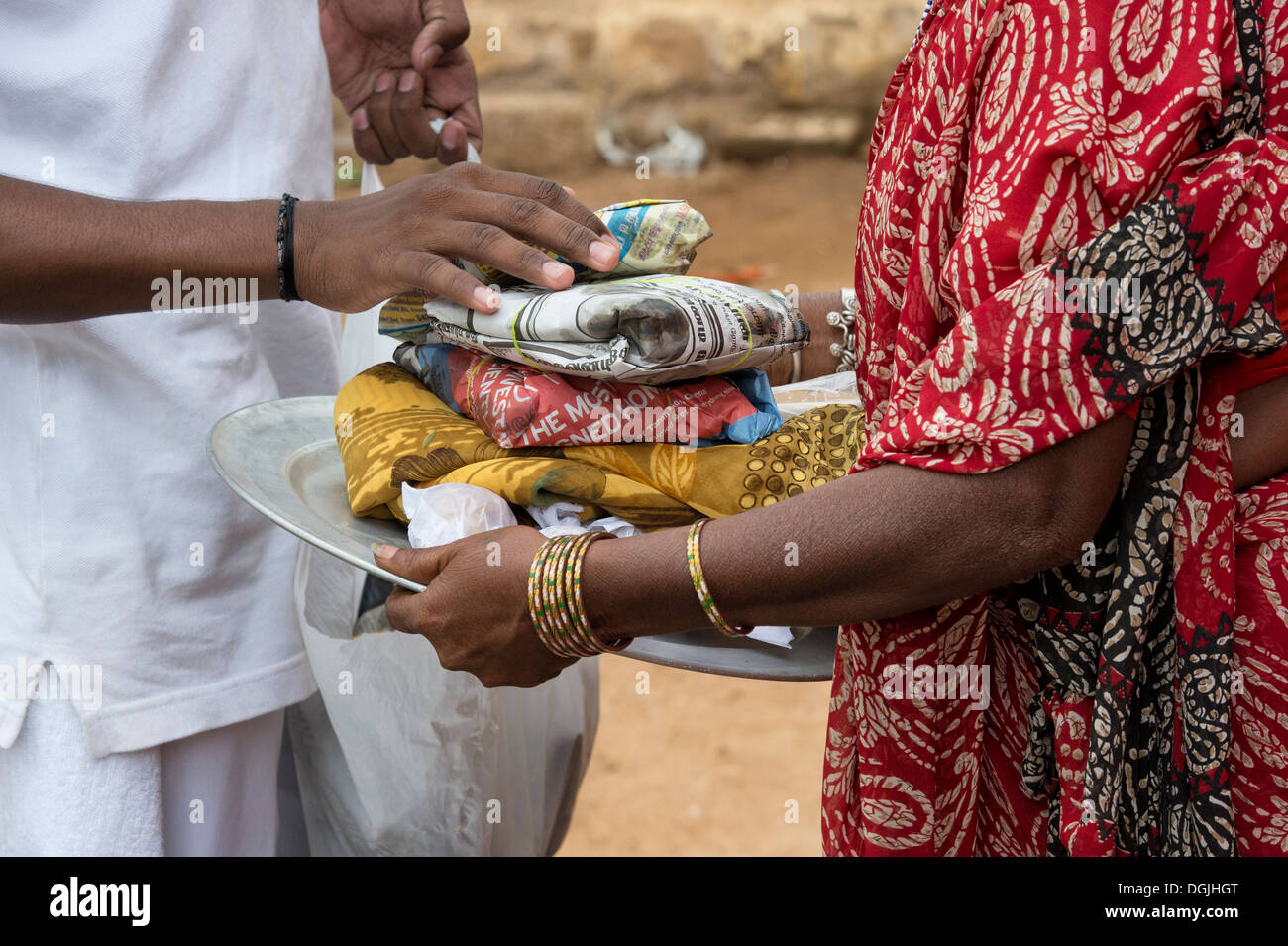 Rurale villaggio indiano donna ricevere doni di cibo e vestiti dato da Sri Sathya Sai Baba organizzazione. Puttaparthi, Andhra Pradesh, India Foto Stock