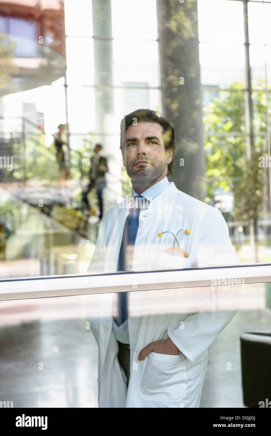 Ritratto di medico maschio guardando fuori della finestra Foto Stock