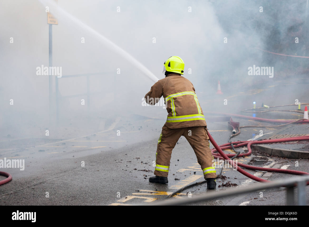 Un membro dell'Essex servizio antincendio affronta un incendio con un tubo flessibile. Foto Stock