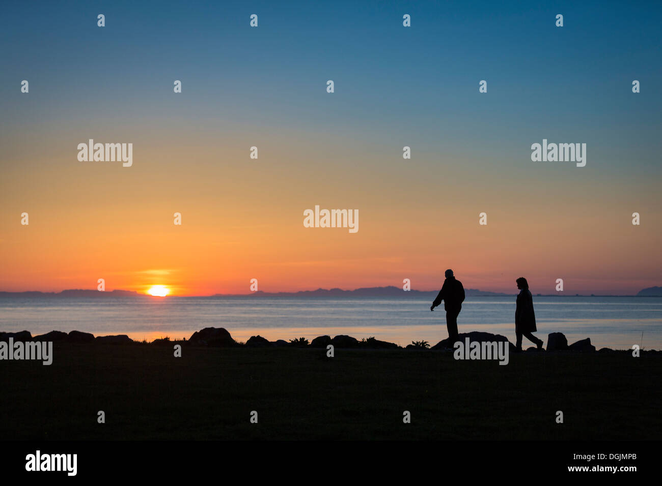 Giovane godendo di una passeggiata sotto il sole di mezzanotte, Seltjarnarnes, Reykjavik, Islanda Foto Stock