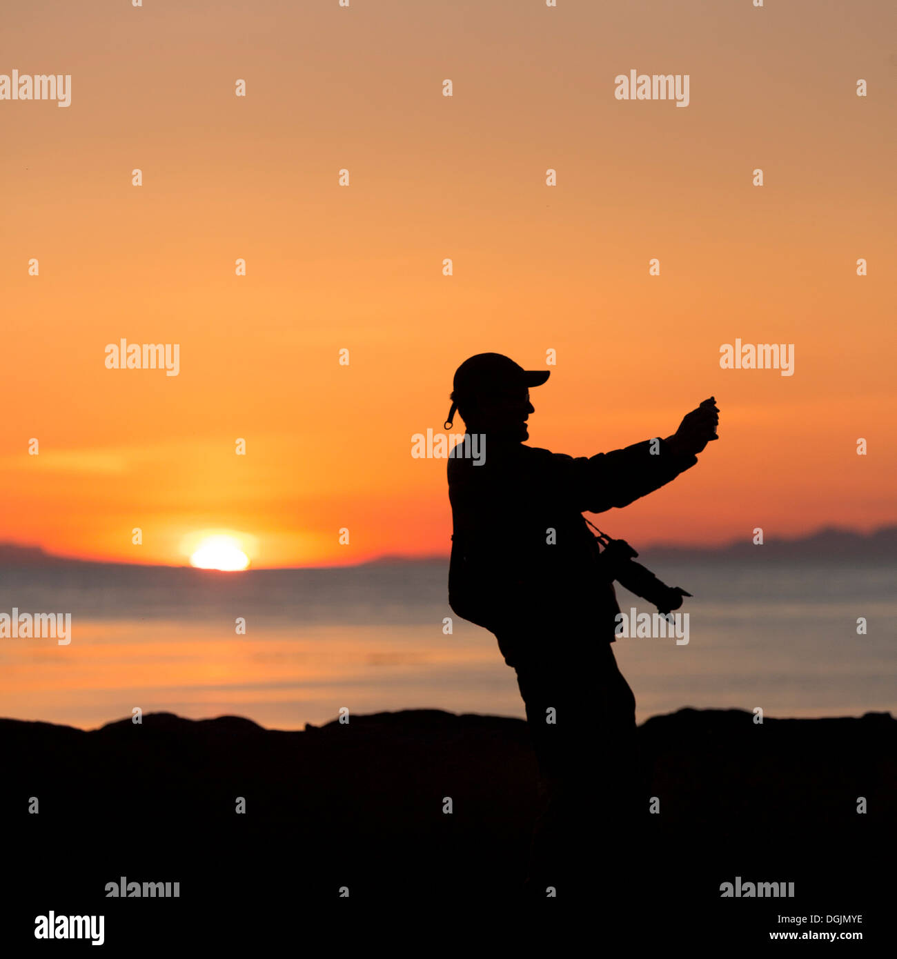 Silhouette sotto il sole di mezzanotte, Seltjarnarnes, Reykjavik, Islanda Foto Stock