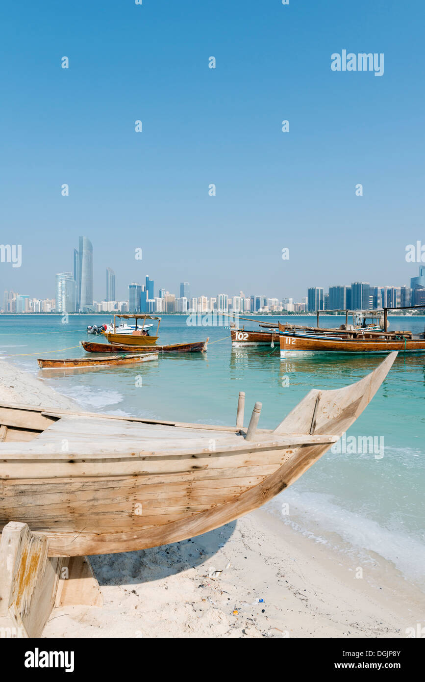Skyline del moderno Abu Dhabi e vecchie imbarcazioni di pesca artigianale nel Villaggio del Patrimonio Culturale di Abu Dhabi negli Emirati Arabi Uniti EMIRATI ARABI UNITI Foto Stock