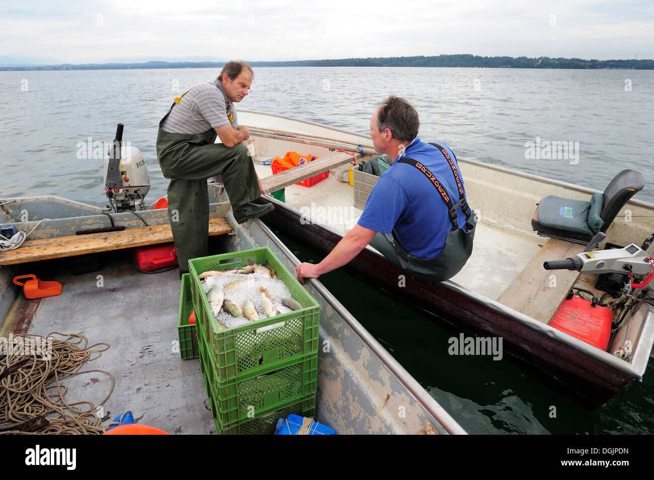 Due pescatori in chat sul Lago di Starnberg, area Fuenfseenland, Alta Baviera, Baviera Foto Stock