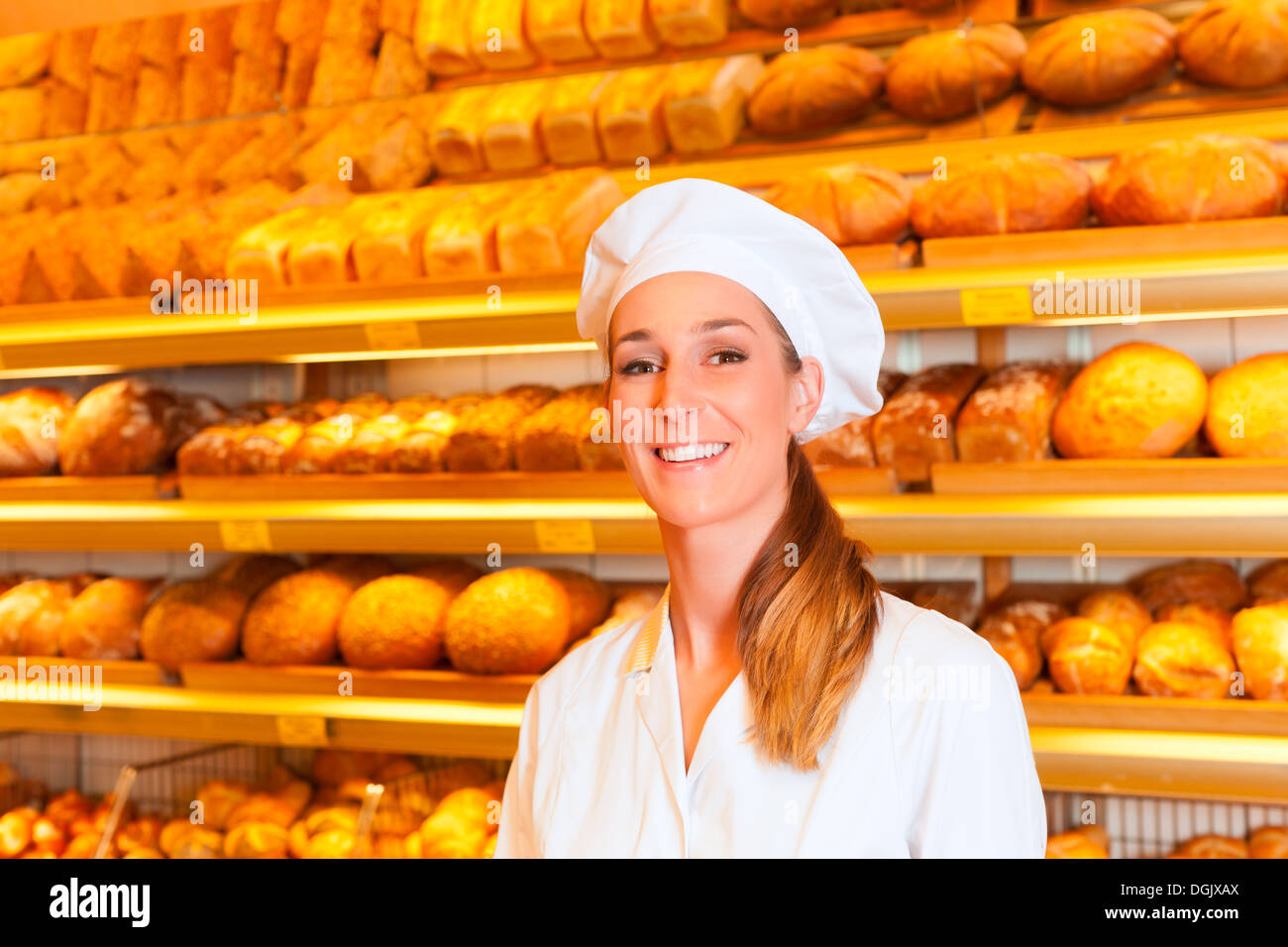 Il panettiere femmina o commessa nel suo panificio vendita di pane fresco,  dolci e prodotti da forno Foto stock - Alamy