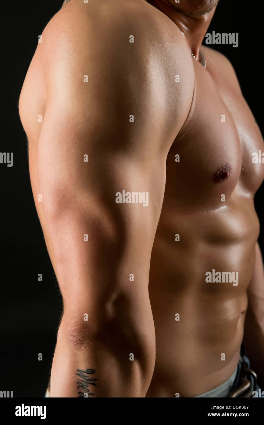 Nudo maschile uomo torace con nudi muscolosi torso pecs abs indossano jeans  isolato su sfondo nero tatuaggio visibile Foto stock - Alamy