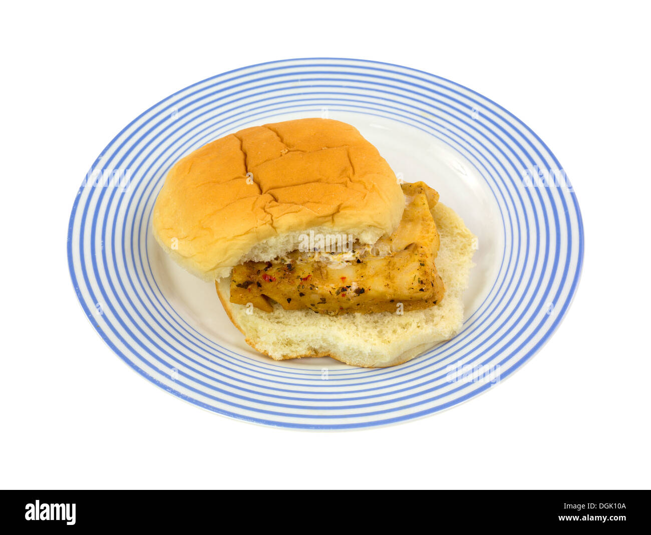 Una porzione di cotto in forno a microonde eglefino tra un pane bianco bun su un blu piastra striato. Foto Stock