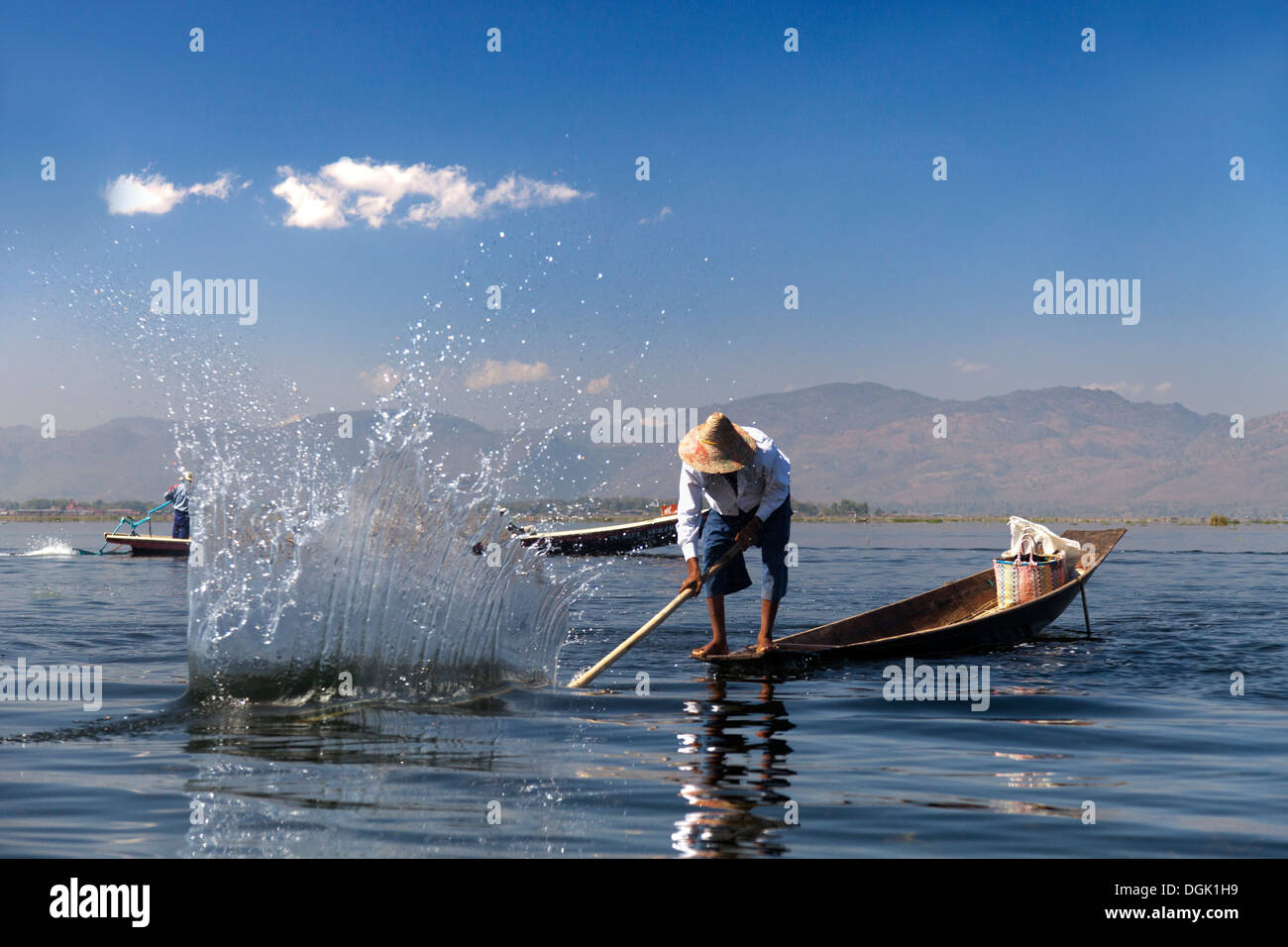 Fisherman battendo l'acqua per attirare i pesci sul Lago Inle in Myanmar. Foto Stock