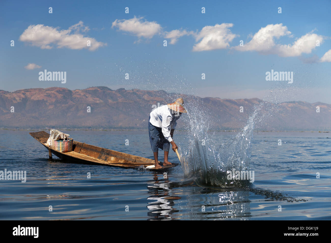 Fisherman battendo l'acqua per attirare i pesci sul Lago Inle in Myanmar. Foto Stock