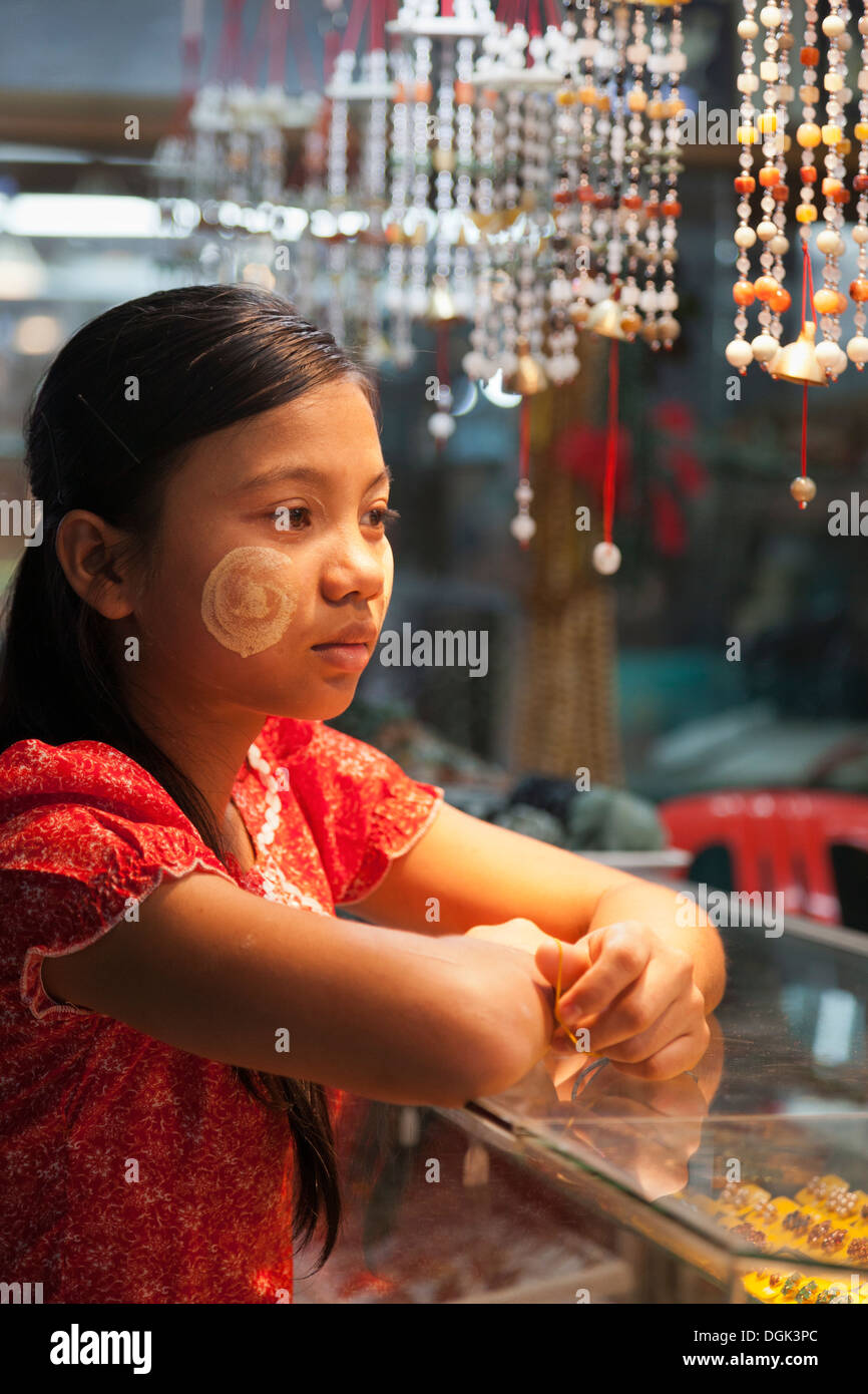 Una giovane ragazza birmano con faccia Thanaka decorazione in Bogyoke (ex Scott) Mercato di Yangon in Myanmar. Foto Stock