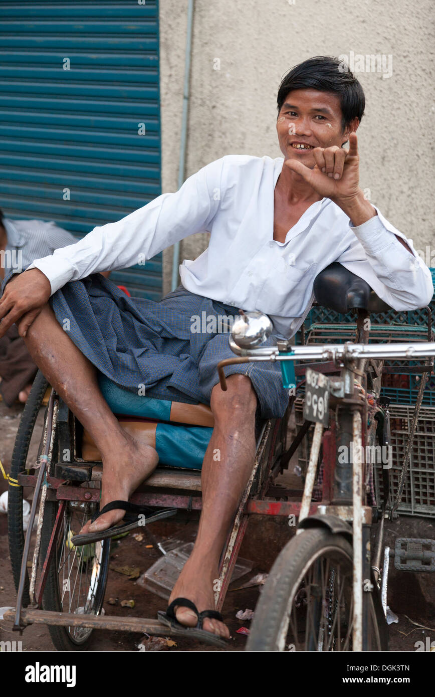 Laid-back trike rider per il noleggio nel mercato indiano di Yangon in Myanmar. Foto Stock