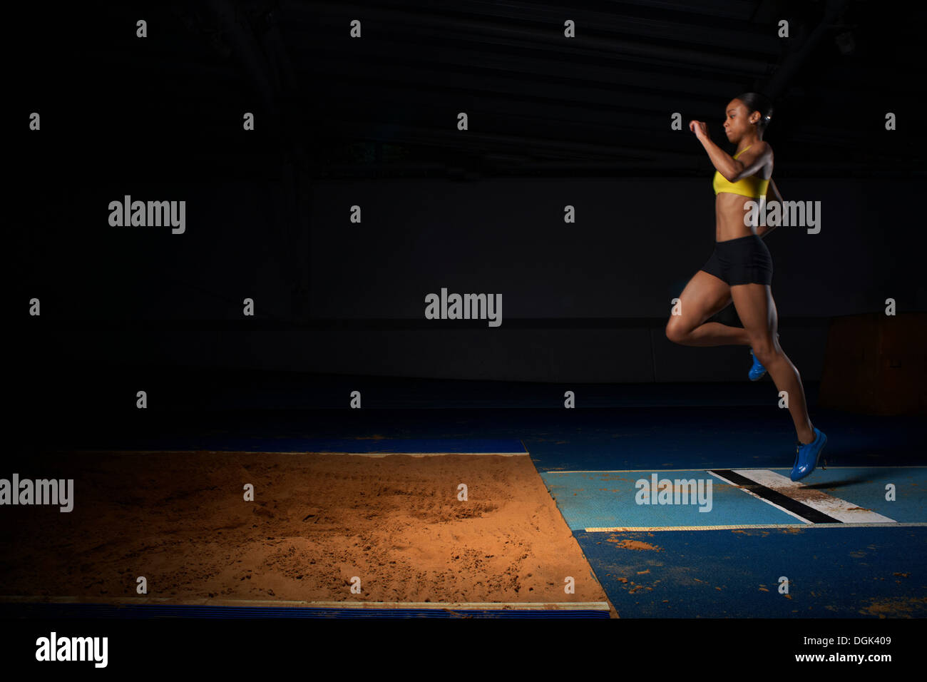 Giovane atleta femminile di fare il salto in lungo Foto Stock