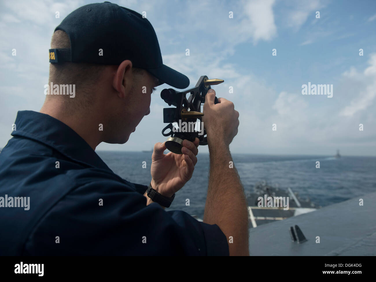 Alfiere Jed Teobaldo utilizza un sestante per misurare la distanza tra il Arleigh Burke-class guidato-missile cacciatorpediniere USS Preble Foto Stock