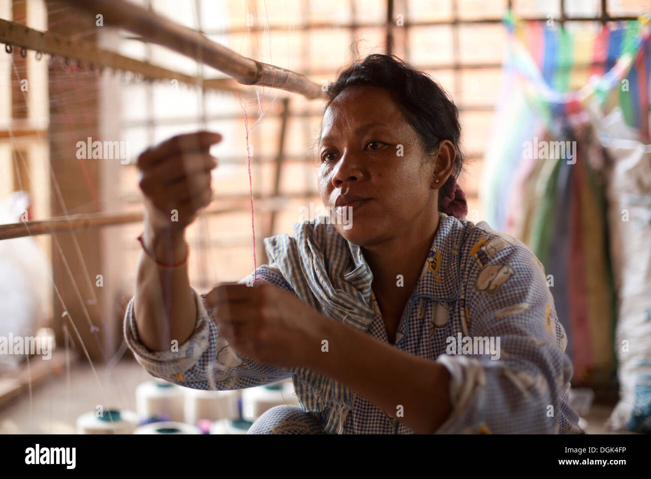 Una donna lavora in un piccolo villaggio fabbrica tessile al di fuori di Phnom Penh Cambogia. Foto © Dennis Drenner 2013. Foto Stock