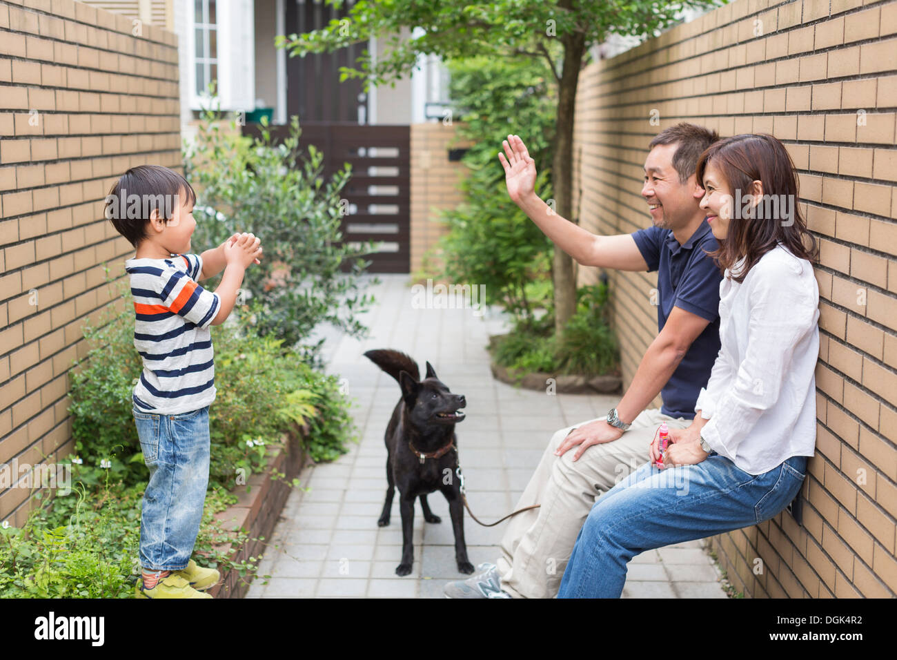 Famiglia con cane, padre sventolare al figlio Foto Stock