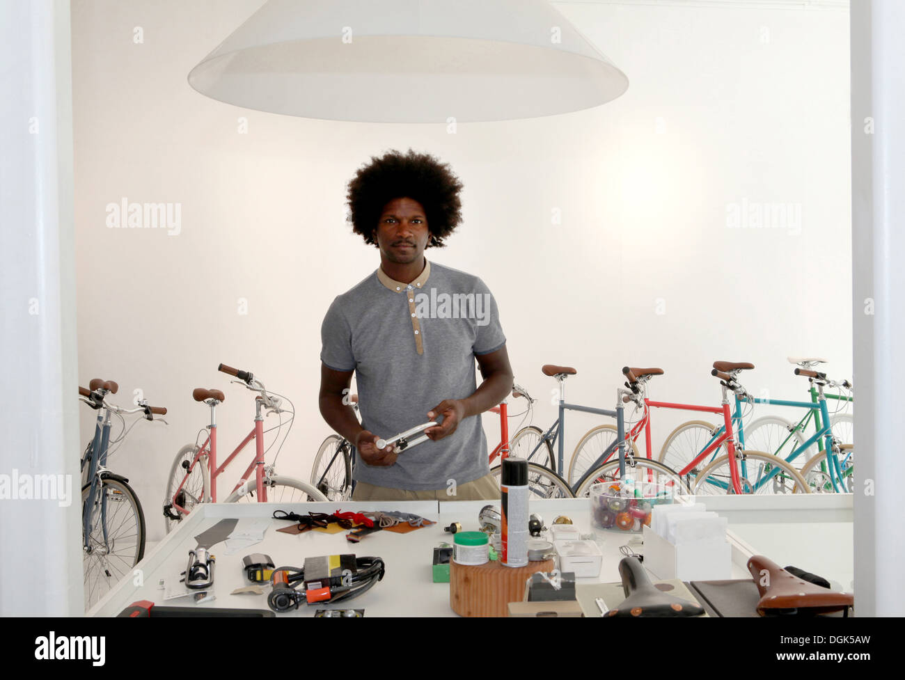 Uomo maturo a lavorare nel negozio di riparazione di biciclette Foto Stock