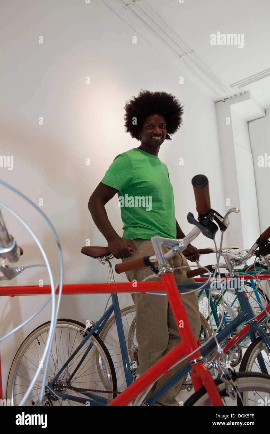 Uomo maturo con la bici in negozio di biciclette Foto Stock