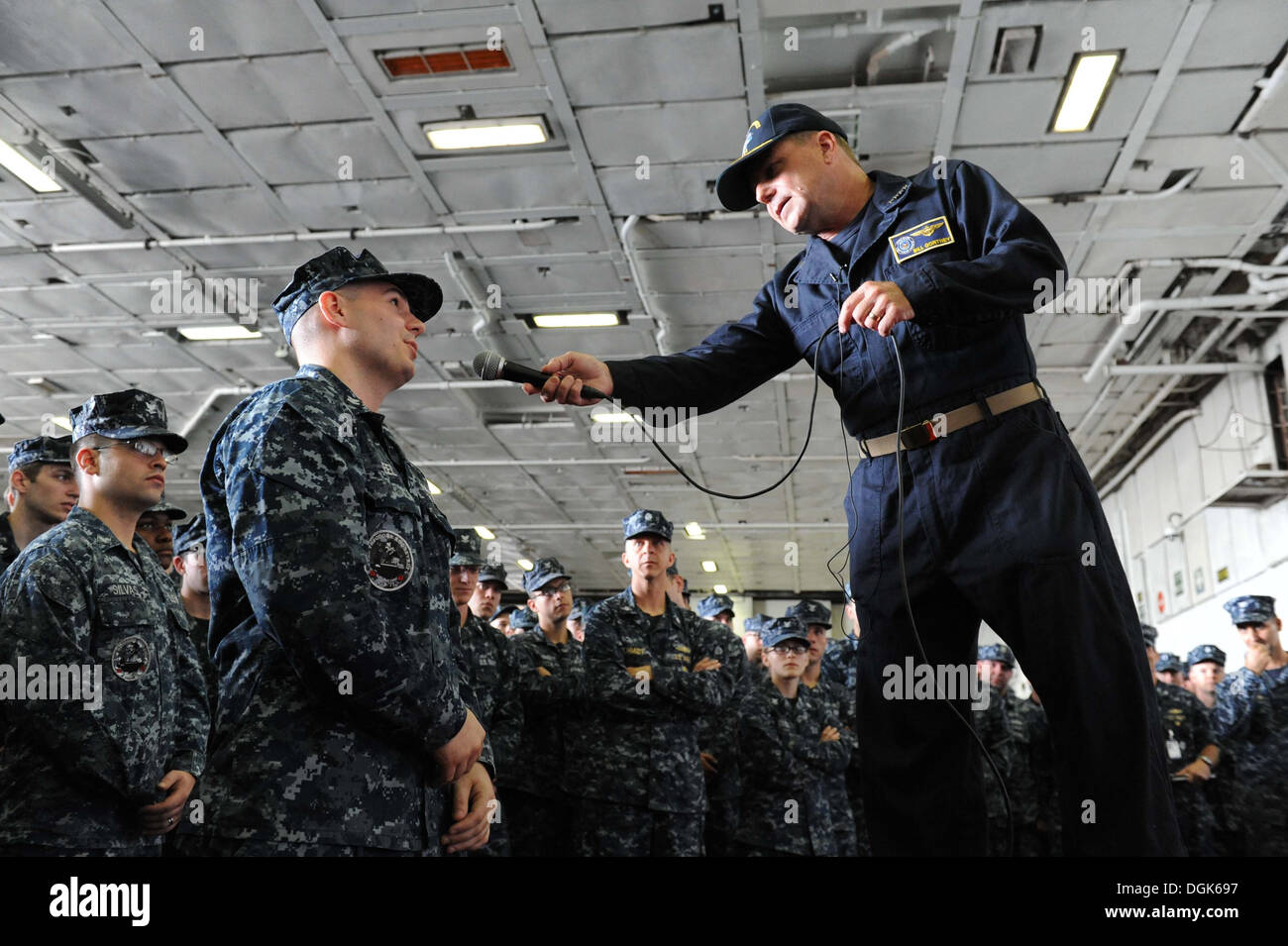 Per elettricista mate 1. classe Dilion Deel chiede Adm. Bill Gortney, comandante della U.S. Flotta navale il comando delle forze, una domanda a bordo della portaerei USS Theodore Roosevelt CVN (71) durante un tutte le mani con la chiamata. Gortney risponde alle domande di l'equipaggio come wel Foto Stock