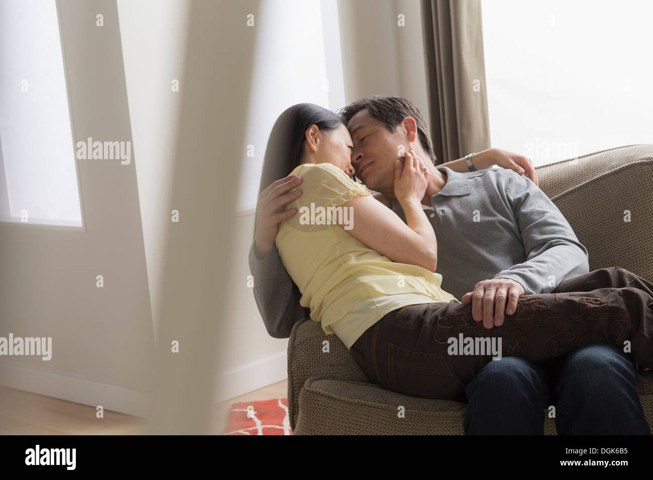 Coppia matura abbracciando sul divano Foto Stock