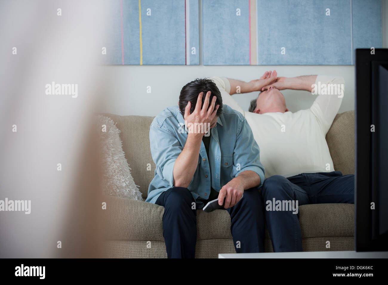 Gli uomini di età matura guardando la tv, testa in mani Foto Stock