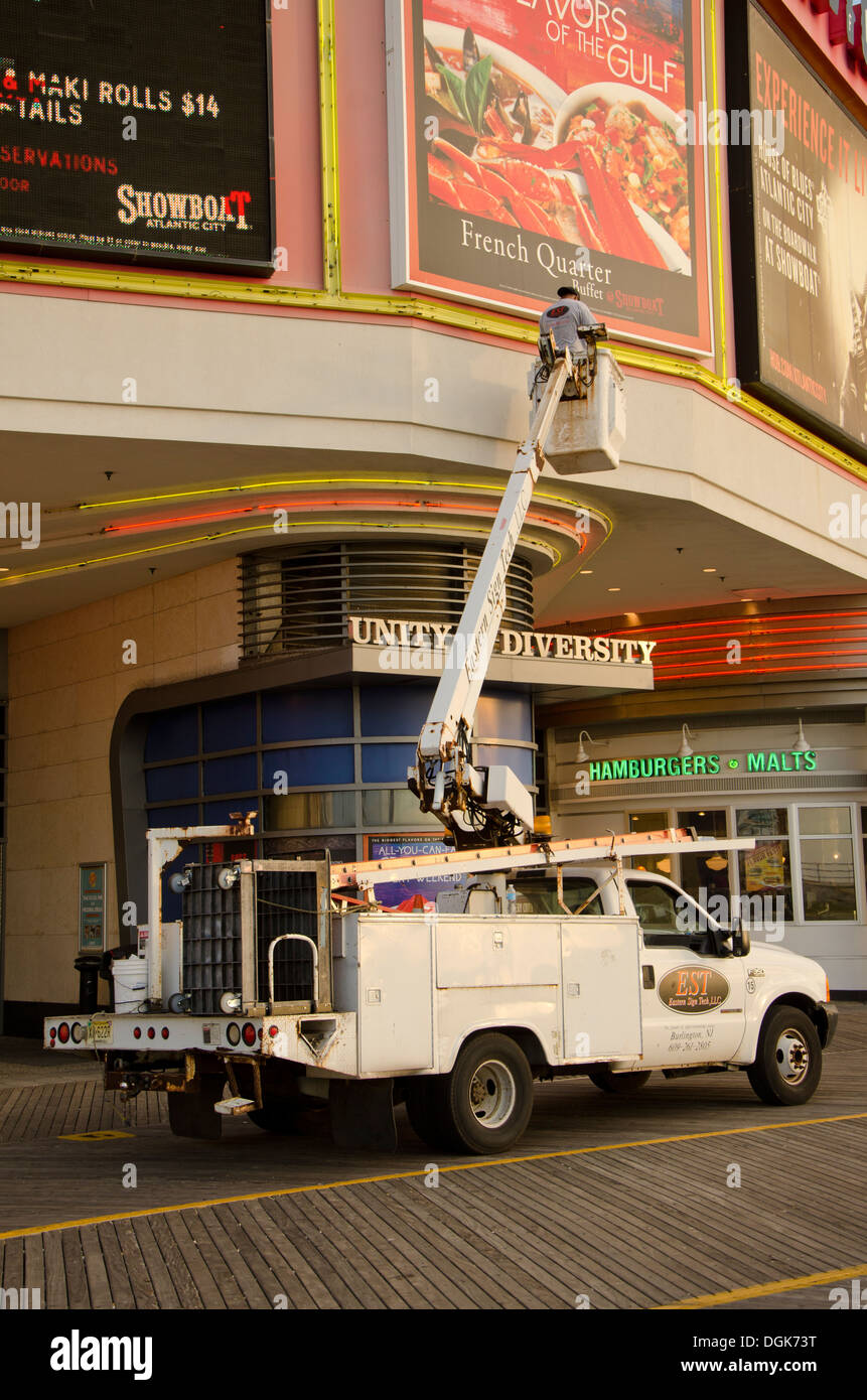 Lavoratore lavora su un cartellone su una gru presso il lungomare di Atlantic City, New Jersey, Stati Uniti Foto Stock
