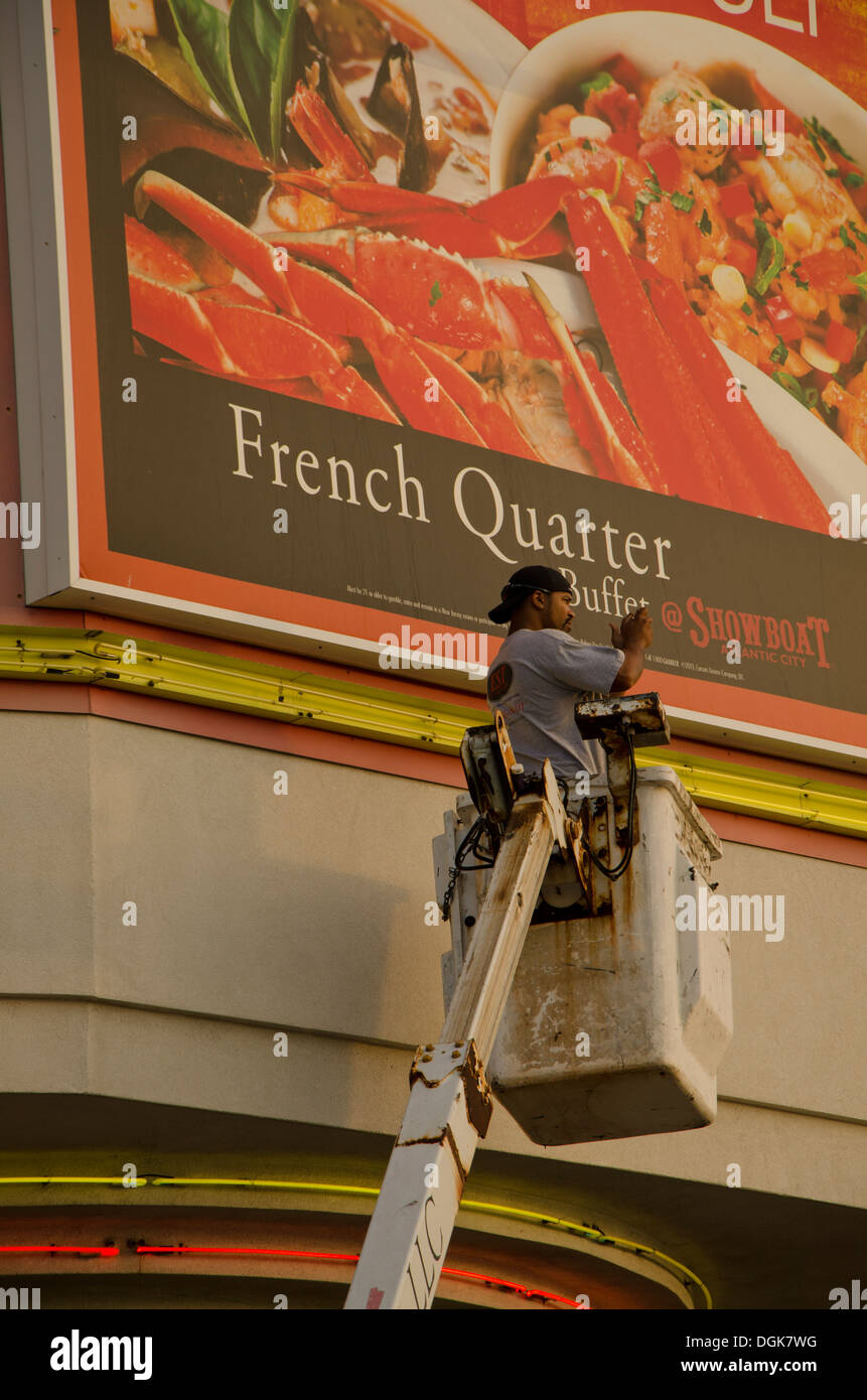 Lavoratore lavora su un cartellone su una gru presso il lungomare di Atlantic City, New Jersey, Stati Uniti Foto Stock