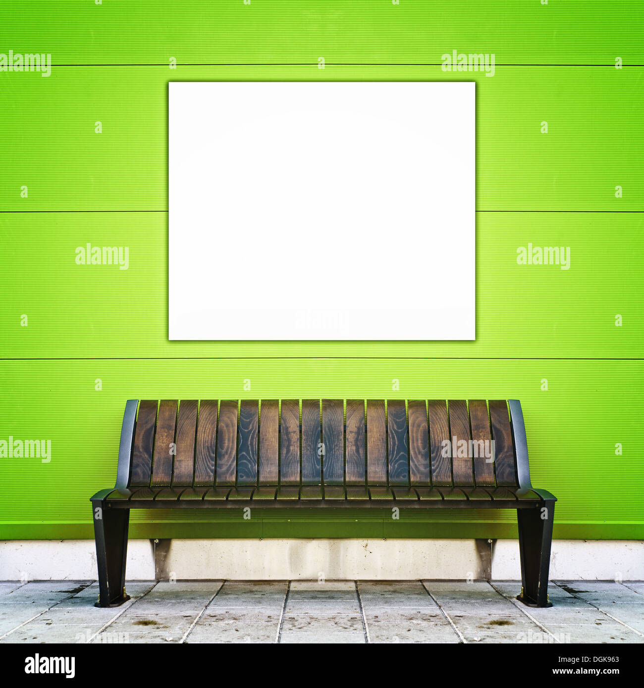 Elegante banco con poster in bianco contro la parete verde come sfondo Foto Stock