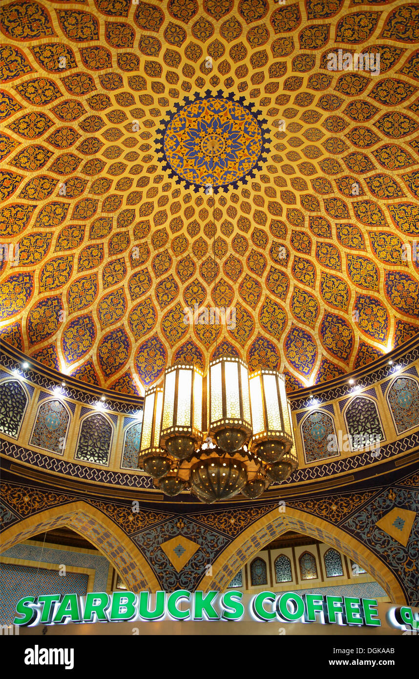 Un tradizionale cupola iraniana contrasta contro un Starbucks nell'Ibn Batutta mall. Foto Stock